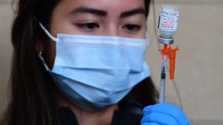 The Moderna Covid-19 vaccine is prepared for administration ahead of a free distribution of over the counter rapid Covid-19 test kits to people receiving their vaccines or boosters at Union Station in Los Angeles, California on January 7, 2022.