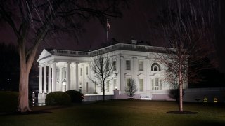 In this photo made with a slow shutter speed, light rain falls outside the White House, Friday, Jan. 28, 2022, in Washington.