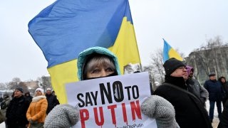 TOPSHOT – A demonstrator holds a placard during an action dubbed #SayNOtoPutin in Kyiv on January 9, 2022. (Photo by SERGEI SUPINSKY/AFP via Getty Images)