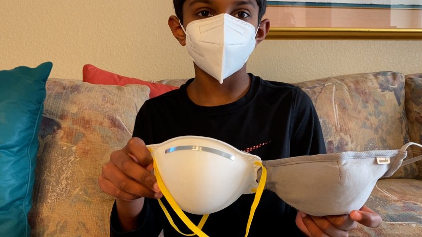 A child holding up three types of masks