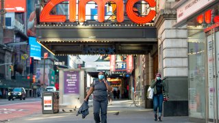 A medical worker wearing a mask walks near the AMC movie theater in Times Square amid the coronavirus pandemic on May 7, 2020 in New York City.