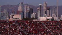 Los Angeles, CA - February 06: With a view of downtown Los Angeles in the background, NASCAR fans watch and cheer as racers circle the quarter-mile track during the Busch Light Clash At The Coliseum, a NASCAR exhibition race at the historic LA Memorial Coliseum in Los Angeles Sunday, Feb. 6, 2022. Joey Logano, #22, went on to win the race. The season-opening Clash exhibition race gets a taste of West Coast flavor in 2022, marking a historic first visit to the tradition-rich Los Angeles Memorial Coliseum. The event is to be contested around a quarter-mile asphalt oval that will be built around the facilitys football field. The Los Angeles event marks the first time the preseason Clash is held outside of Daytona International Speedway since its inception in 1979, and gives the sport its first competitive look at the Next Gen car on Feb. 6 in a non-points event, including a pre-race concert by Pit Bull and Ice Cube. (Allen J. Schaben / Los Angeles Times via Getty Images)