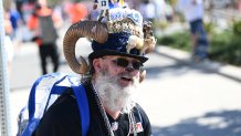 A Rams fan with a highly decorated hat poses