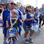 A Rams fan walks with his baby