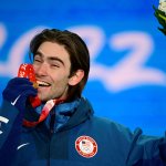 Gold medallist Alexander Hall bites on his medal won from the men's freeski slopestyle event of the 2022 Winter Olympic Games, in Zhangjiakou, China, Feb. 16, 2022.