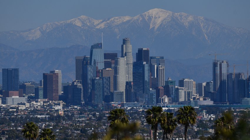 Downtown Los Angeles skyline is seen as snow cover the mountain tops in the distance on February 24, 2022. (Photo by Chris DELMAS / AFP) (Photo by CHRIS DELMAS/AFP via Getty Images)