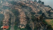 LAGUNA BEACH, CA - OCTOBER 28: Smoke rise from the burned out ruins of homes along Skyline Bld above downtown Laguna Beach 28 October 1993 after the wildfire hit the area 27 Octobre. (Photo credit should read VINCE BUCCI/AFP via Getty Images)