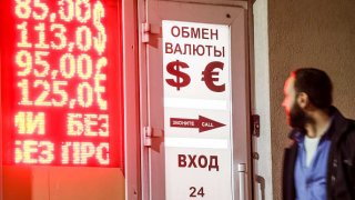 A man views a digital board showing Russian rouble exchange rates against the euro and the US dollar outside a currency exchange office. On March 2, 2022, the Russian rouble hit record lows with the US dollar and the euro rates reaching 110 and 122 at the Moscow Exchange respectively.