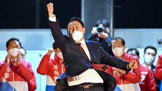 South Korea’s president-elect Yoon Suk-yeol of the main opposition People Power Party gestures to his supporters as he is congratulated outside the party headquarters in Seoul on March 10, 2022.