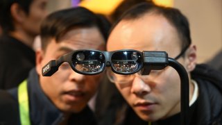 Attendees look at NReal’s augmented reality glasses, on the last day of CES 2019 in Las Vegas, Nevada.