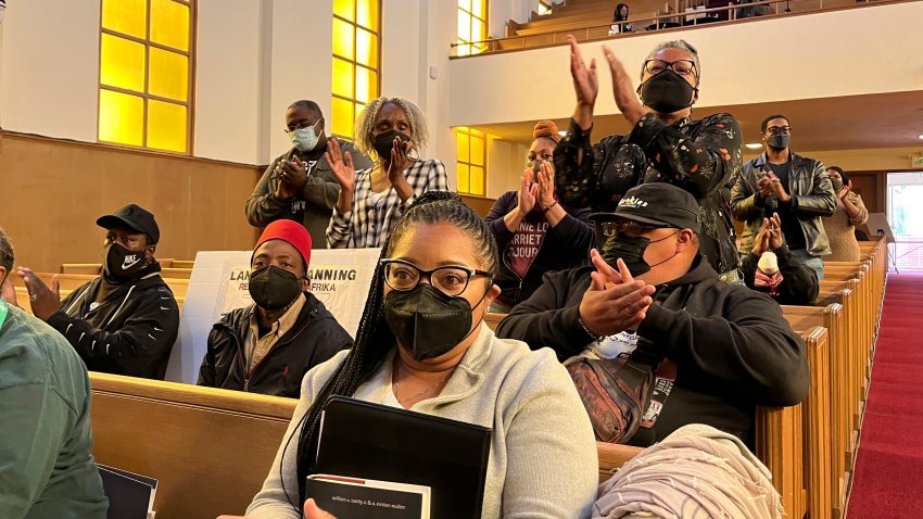 People applaud chair Kamilah Moore during a reparations task force meeting at Third Baptist Church in San Francisco, April 13, 2022. California's first-in-the-nation reparations task force met for the first time since its inaugural meeting nearly a year ago.