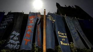 LOS ANGELES – APRIL 21: Blue jeans with messages challenging misconceptions about sexual violence are hung by the UCLA Clothesline Project on the University of California Los Angeles campus during Denim Day April 21, 2004 in Los Angeles, California. The UCLA Clothesline Project is a student organization which works to stop gender-based violence. In 1999, wearing jeans on Denim Day during Sexual Assault Awareness Month became an international symbol of protest against rape in response to an Italian Supreme Court decision, which overturned a rape conviction because the victim wore jeans. The Italian Court justices reasoned that the victim must have helped her attacker remove her jeans because they believed that without the victim’s help, removing the jeans would be impossible. (Photo by David McNew/Getty Images)