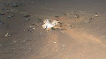 Perseverance’s backshell, supersonic parachute, and associated debris field is seen strewn across the Martian surface in this image captured by NASA’s Ingenuity Mars Helicopter during its 26th flight on April 19, 2022.