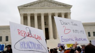 Demonstrators hold up signs during a protest outside the U.S. Supreme Court, after the leak of a draft majority opinion written by Justice Samuel Alito preparing for a majority of the court to overturn the landmark Roe v. Wade abortion rights decision later this year, in Washington, U.S. May 3, 2022.
