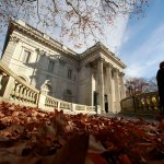 A woman walks past the front entrance to Marble House mansion, in Newport, R.I.