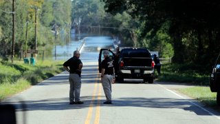 FILE - Responders congregate near where two people drowned the evening before when they were locked in a Horry County Sheriff's department transport van in Marion County, S.C. A deputy charged in the deaths ignored barricades and drove into rapidly rising floodwaters against advice from his supervisors and officials on the South Carolina highway, a prosecutor said Monday, May, 16, 2022.