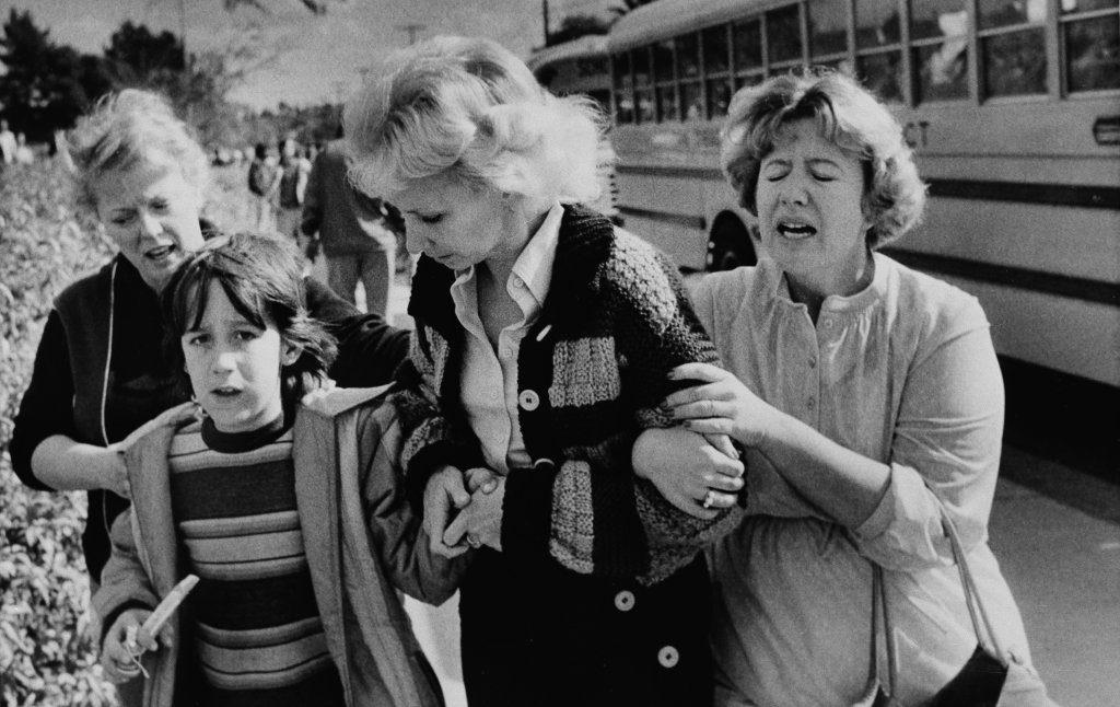 Unidentified women greet a young boy who was evacuated by bus to a nearby junior high school in San Diego from the schoolyard of the Cleveland Elementary School after a sniper opened fire on the schoolyard, Jan. 29, 1979.