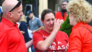 Jules Woodson, center, of Colorado Springs, Colo., is comforted by her boyfriend Ben Smith, left, and Christa Brown during a demonstration outside the Southern Baptist Convention's annual meeting