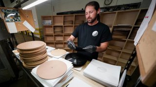 Ricky Riehl inspects finished vinyl records for physical flaws
