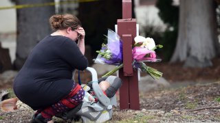 A woman who declined to give her name cries after placing flowers at a sign at the Veterans Home of California, the morning after a hostage situation in Yountville, Calif., on Saturday, March 10, 2018. A daylong siege at The Pathway Home ended Friday evening with the discovery of four bodies, including the gunman, identified as Albert Wong, a former Army rifleman who served a year in Afghanistan in 2011-2012.
