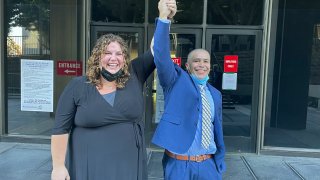 In this photo provided by the California Innocence Project, staff attorney Audrey McGinn raises her hand with Alexander Torres after he was released from a Criminal Justice Center in Los Angeles on Oct. 19, 2021.