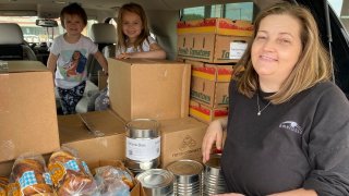 Kisha Galvan and her grandchildren, pose for a photo after stocking up on food items from the Northern Illinois Food Bank