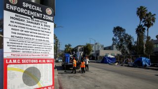 A homeless encampment special enforcement zone sign is pictured.