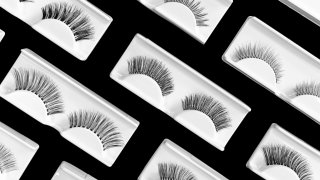 Different fake eyelashes on trendy black background. Beauty pattern. Makeup accessories concept. Cosmetics products for women. Eye lash extension tools. Closeup. Top view, flat lay. Layout. Banner.