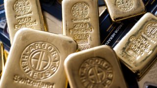 An Argor-Heraeus SA branded two hundred and fifty gram gold bar, center, sits in this arranged photograph at Solar Capital Gold Zrt. in Budapest, Hungary.