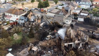 An aerial view shows the rubble and destruction in a residential area following a large blaze the previous day, on July 20, 2022 in Wennington, Greater London.