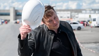 17 May 2021, Brandenburg, Grünheide: Elon Musk, Tesla CEO, stands on the construction site of the Tesla factory and greets with his hard hat.