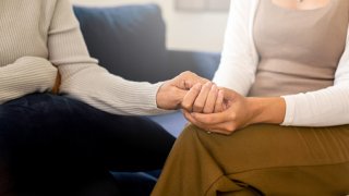 Caregiver women holding hands to elderly with alzheimer disease at home,Adult social care concept