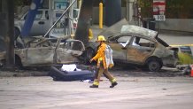 Firefighters walks past wreckage of car crash