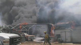 Several trailers and vehicles were destroyed Sunday when a palm tree fire spread to structures in the Riverside County community of Woodcrest.