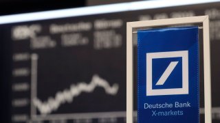 A banners of Deutsche Bank is pictured in front of the German share price index, DAX board, at the stock exchange in Frankfurt, Germany, September 30, 2016.