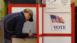 A voter fills out a ballot for the Massachusetts primary election at a polling station in Attleboro, Massachusetts, Sept. 6, 2022.