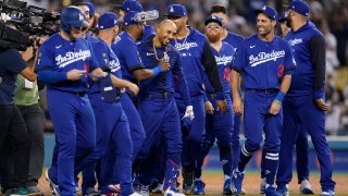 Los Angeles Dodgers’ Mookie Betts, center, is greeted by teammates after he hit a walk-off single to win a baseball game 3-2 against the Arizona Diamondbacks in Los Angeles, Thursday, Sept. 22, 2022. Freddie Freeman scored. (AP Photo/Ashley Landis)