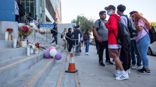 Students exit their school and stand next to a memorial on the steps on Friday, Sept. 16, 2022, in Hollywood.