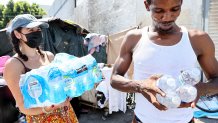 LOS ANGELES, CALIFORNIA - SEPTEMBER 04: A member of the Skid Row community carries away water distributed by volunteers with Water Drop LA on September 4, 2022 in Los Angeles, California. Temperatures hovered around 100 degrees in downtown L.A. amid an intense heat wave in Southern California. Water Drop LA is a mutual aid organization which drops off 2,000 gallons of water each Sunday to members of the Skid Row community, many of who are suffering from water insecurity. Skid Row is home to thousands of people who either live on the streets or in shelters. The National Weather Service issued an Excessive Heat Warning for most of Southern California through September 7. Climate models almost unanimously predict that heat waves will become more intense and frequent as the planet continues to warm. (Photo by Mario Tama/Getty Images)