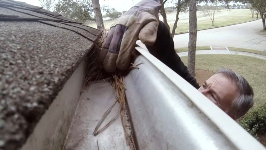 Man cleans a gutter