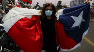 A supporter of Chilean presidential candidate Gabriel Boric carries a Chilean flag as supporters celebrate after their candidate won the presidential election, in Santiago, Chile, December 19, 2021.