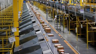 A fast moving conveyor moves packages to delivery trucks during operations on Cyber Monday at Amazon’s fulfillment center in Robbinsville, New Jersey, November 29, 2021.