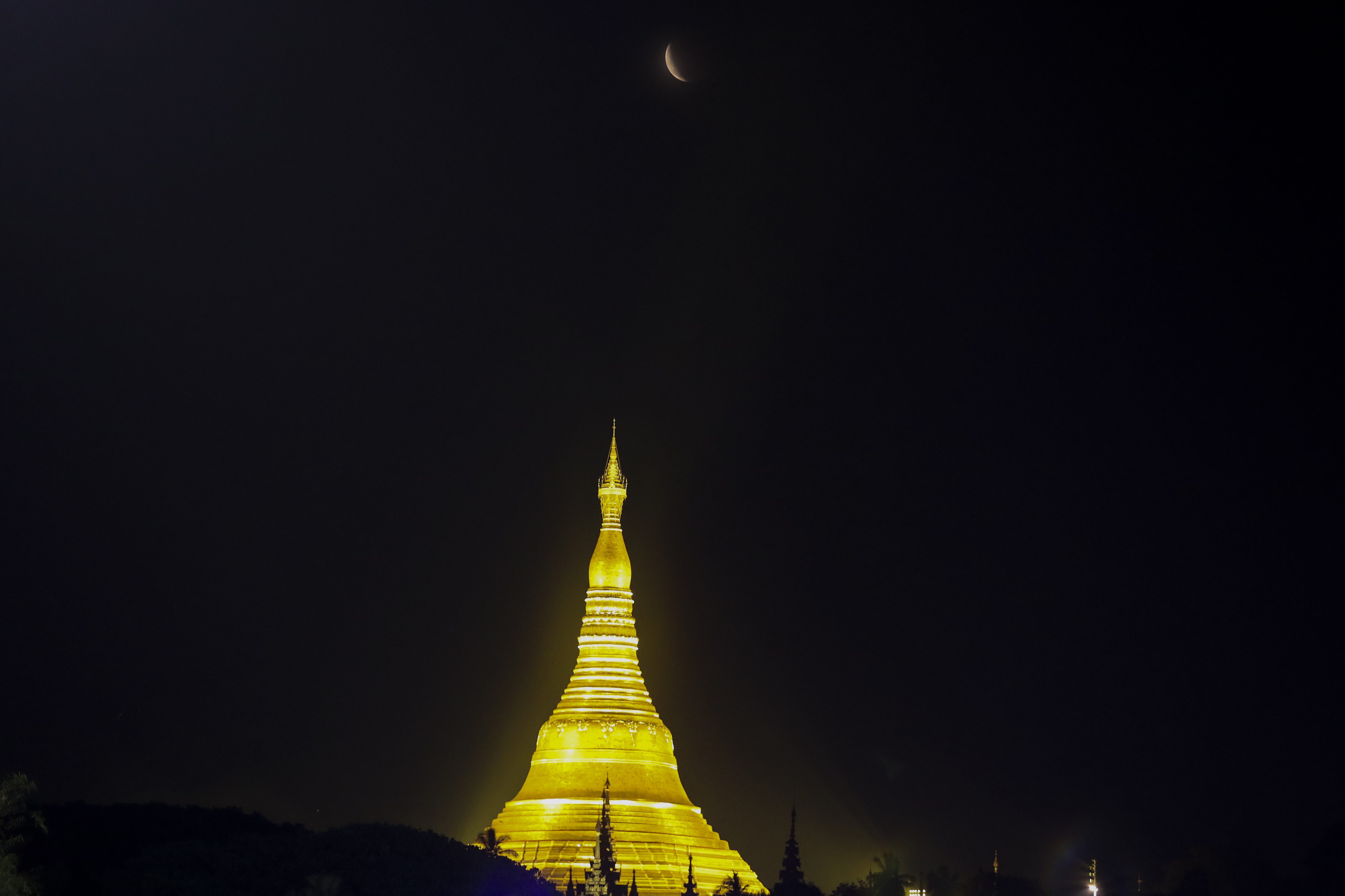 The moon rises above Myanmar Landmark Shwedagon pagoda during a lunar eclipse in Yangon, Myanmar, Nov. 8, 2022.