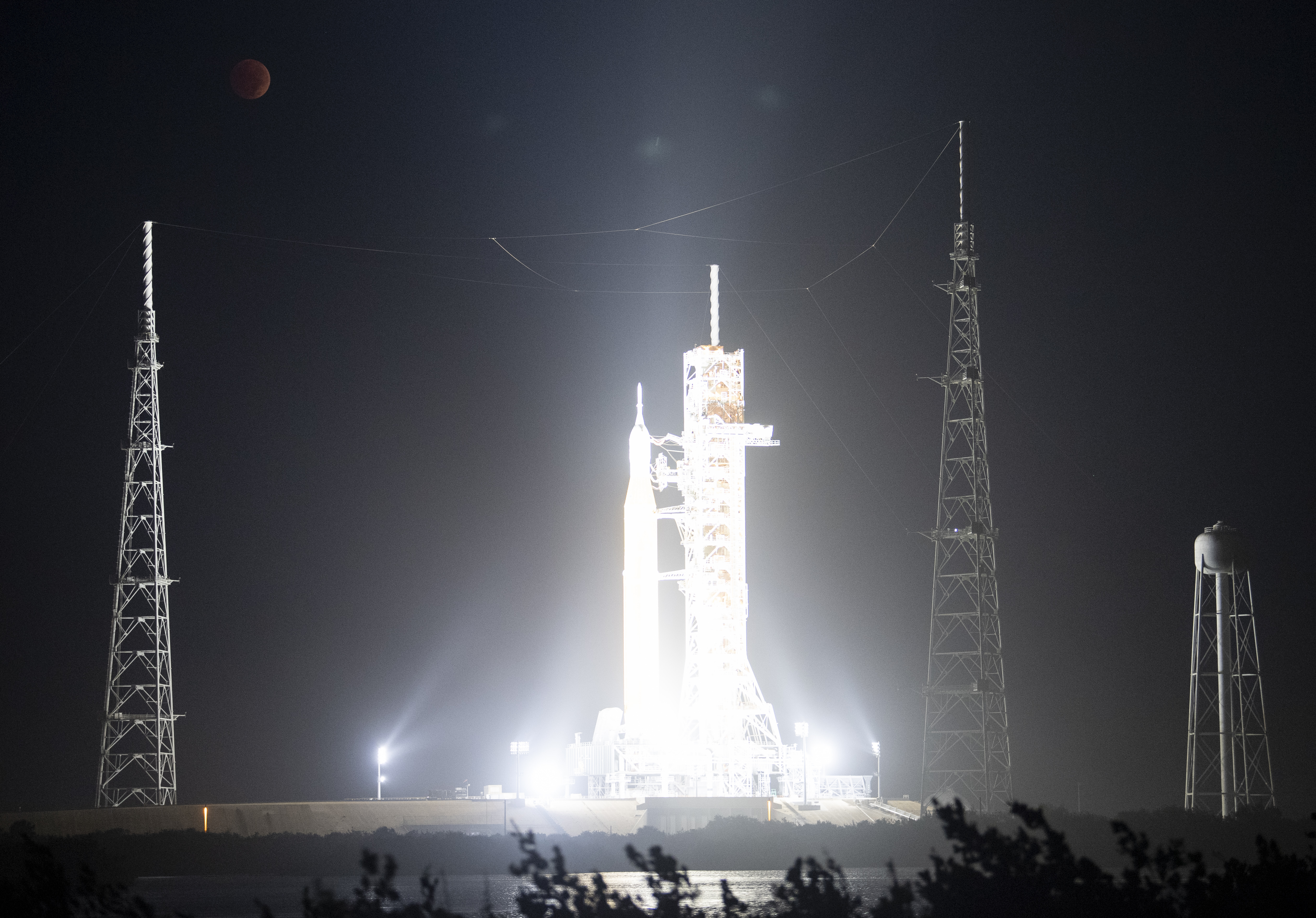 The moon is seen during a total lunar eclipse above NASA’s Space Launch System rocket with the Orion spacecraft  at NASA’s Kennedy Space Center, Nov. 8, 2022, in Cape Canaveral, Florida.