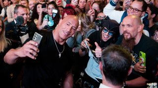 Actor Dwayne Johnson poses with fans.