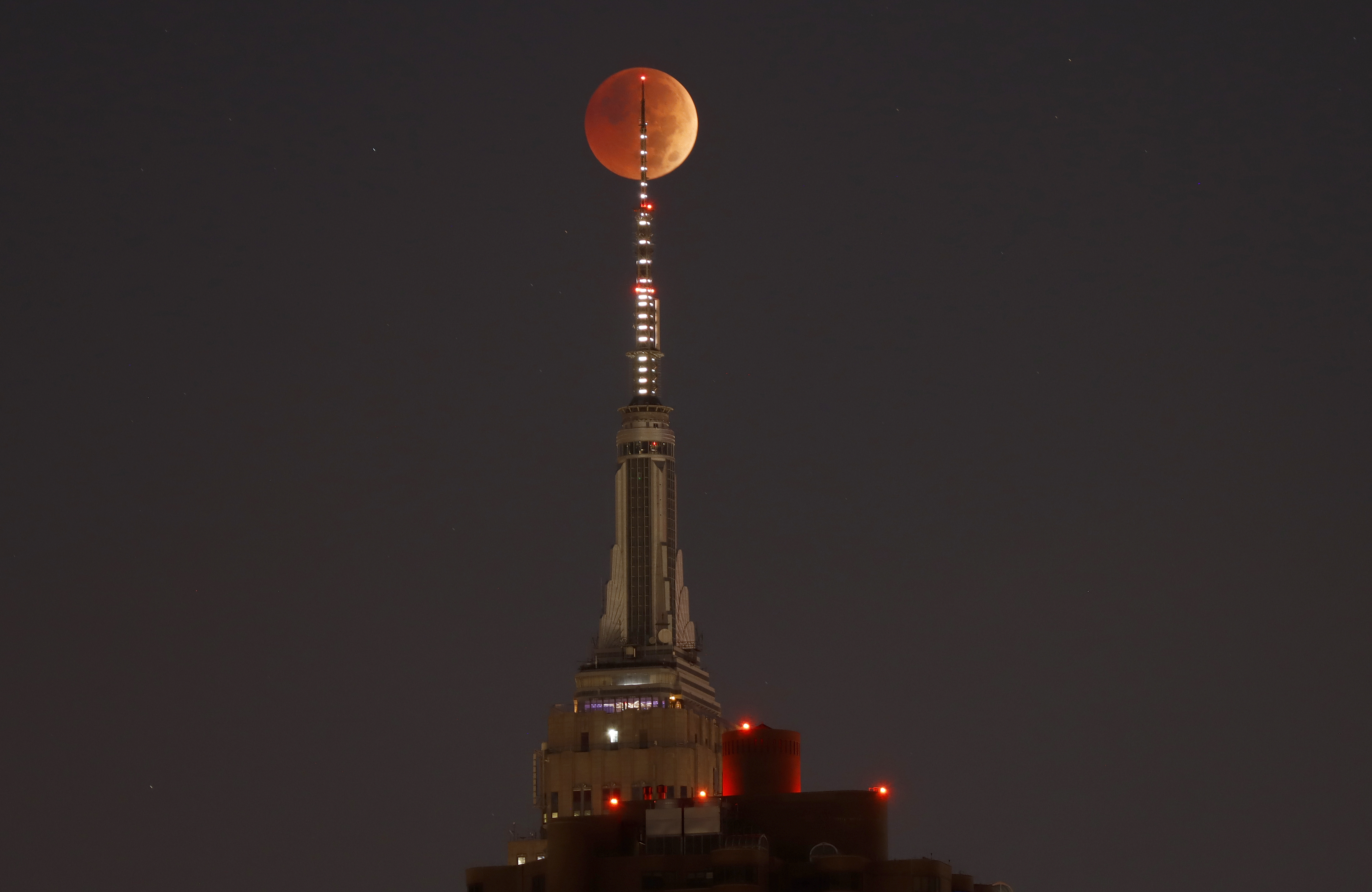 The blood-red full Beaver Moon passes behind the Empire State Building during a total lunar eclipse on Nov. 8, 2022, in New York City.