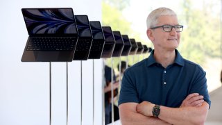 CUPERTINO, CALIFORNIA – JUNE 06: Apple CEO Tim Cook looks at a display of brand new redesigned MacBook Air laptop during the WWDC22 at Apple Park on June 06, 2022 in Cupertino, California. Apple CEO Tim Cook kicked off the annual WWDC22 developer conference.  (Photo by Justin Sullivan/Getty Images)