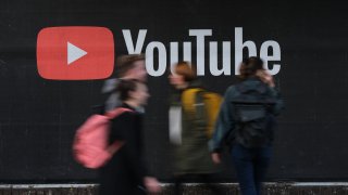 People walk past a billboard advertisement for YouTube on September 27, 2019 in Berlin, Germany.