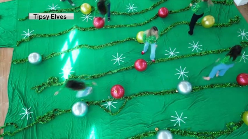 A still image of the Tipsy Elves team creating their giant ugly Christmas sweater.