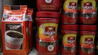 Packages Dunkin’ Donuts and Folgers coffee are displayed on a shelf at a grocery store in San Rafael, California.